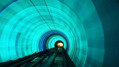 Blurred tunnel lighting stretched into horizontal bands of motion.