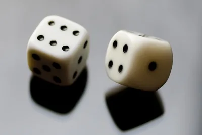 A handful of six-sided dice resting on a wooden table.