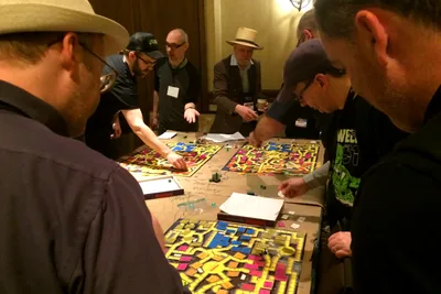 Players gathered around a table mid-way through a board game.