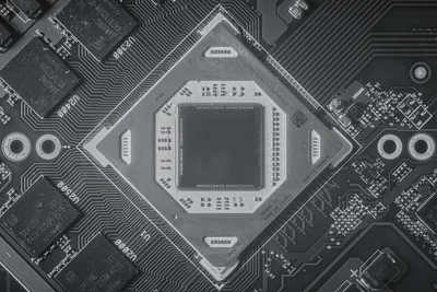 A processor lifted from its socket, contacts catching the light.