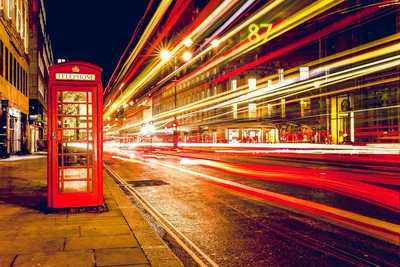 Night traffic moving through a London street, headlights drawn into lines.