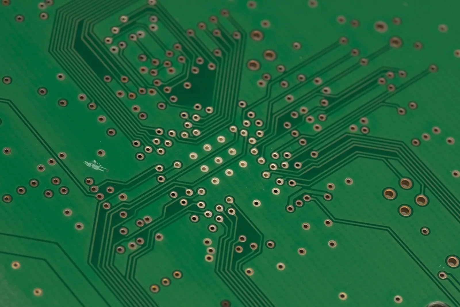 Close-up of a motherboard, its capacitors, sockets and traces in shallow focus.